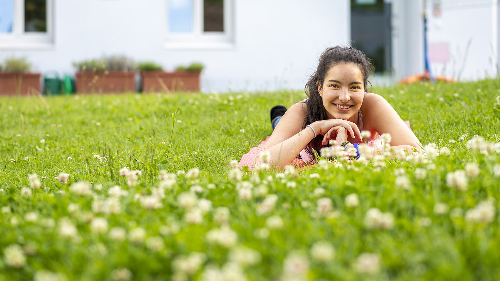 Una ragazza è sdraiata sull'erba nel giardino del Koflerstiftung Mädchenheim a Bolzano